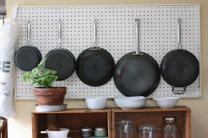 Hang a slab of pegboard that you can easily reach—meaning away from the stove to avoid hard-to-clean grease stains—and hang the cookware you use the most.